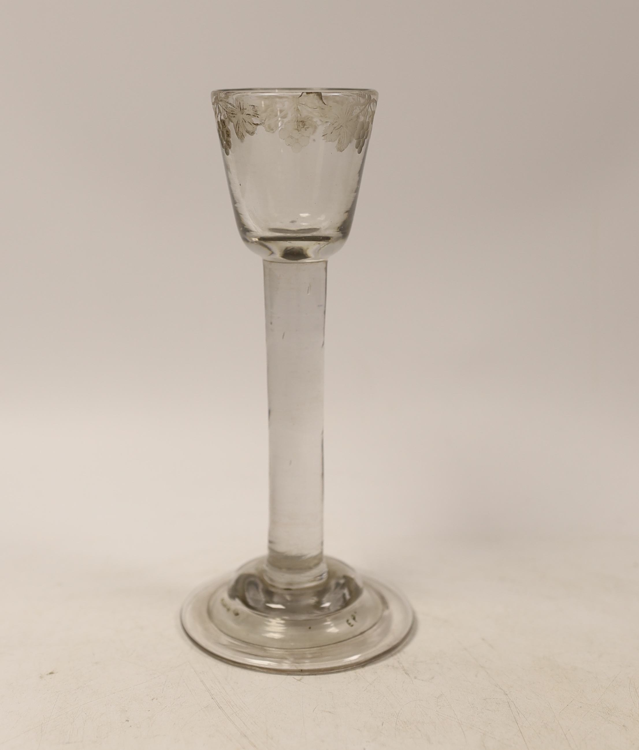 A George I or George II plain stem cordial glass, c.1720-30, with folded and domed foot and wheel engraved rim decorated with grape vines, 17.5cm